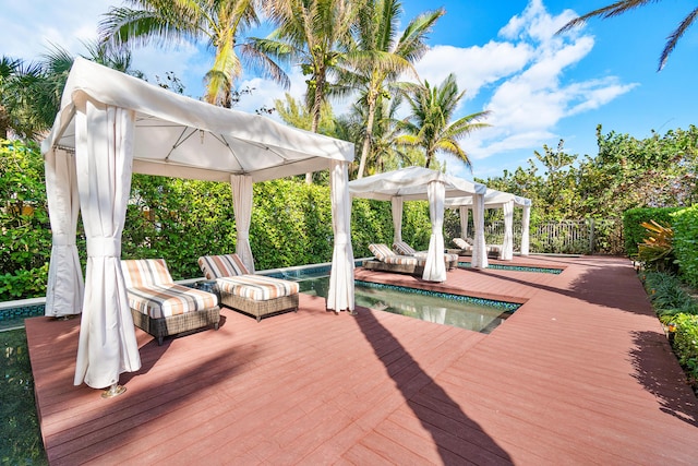 wooden deck featuring a gazebo and fence