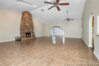 5361 SW Windward Way, Palm City, FL 34990 - unfurnished living room featuring ceiling fan, arched walkways, a stone fireplace, high vaulted ceiling, and baseboards