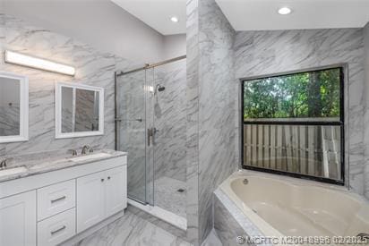 5361 SW Windward Way, Palm City, FL 34990 - full bathroom with marble tiled flooring, a marble finish shower, a bath, double vanity, and recessed lighting