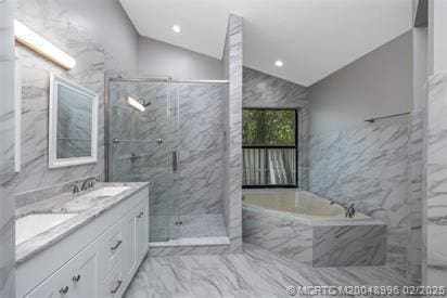 5361 SW Windward Way, Palm City, FL 34990 - bathroom with marble look tiles, vaulted ceiling, a marble finish shower, a garden tub, and double vanity
