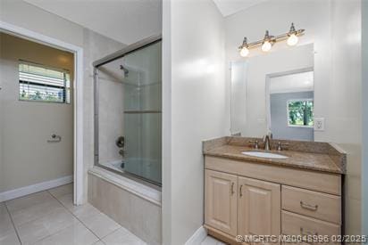 5361 SW Windward Way, Palm City, FL 34990 - bathroom with tile patterned flooring, vanity, healthy amount of natural light, and bath / shower combo with glass door
