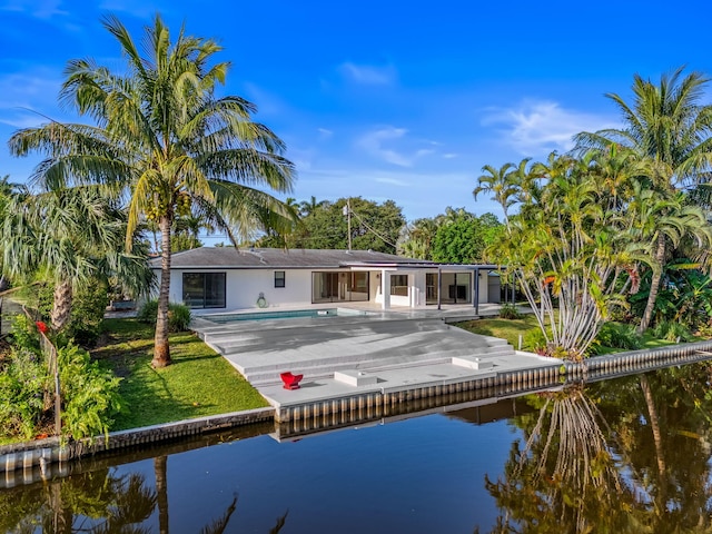1516 Wagner Cir, Lake Clarke Shores, FL 33406 - back of house with a water view, a patio, and an outdoor pool