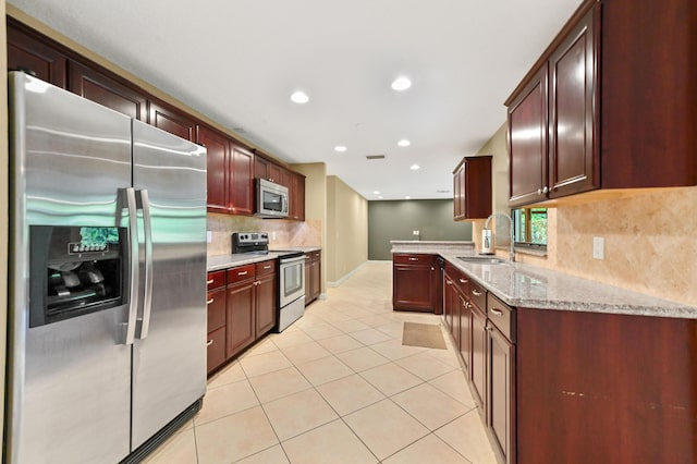 2602 SW 23rd Cranbrook Dr, Boynton Beach, FL 33436 - kitchen featuring stainless steel appliances, a sink, light tile patterned floors, backsplash, and light stone counters