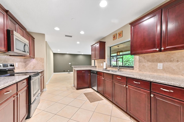 2602 SW 23rd Cranbrook Dr, Boynton Beach, FL 33436 - kitchen featuring stainless steel appliances, dark brown cabinets, a sink, light tile patterned floors, and tasteful backsplash