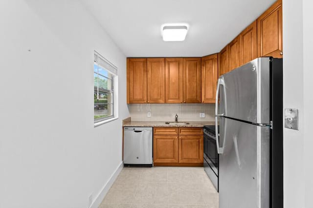 556 Mansfield N, Boca Raton, FL 33434 - kitchen featuring stainless steel appliances, a sink, brown cabinetry, and decorative backsplash