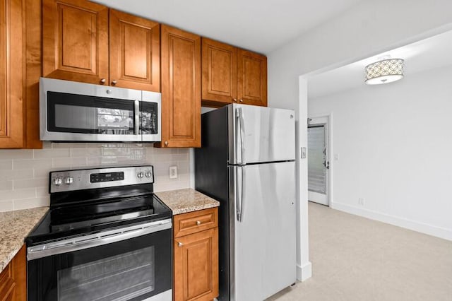 556 Mansfield N, Boca Raton, FL 33434 - kitchen featuring appliances with stainless steel finishes, brown cabinets, and backsplash