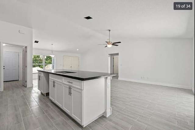 kitchen featuring wood tiled floor, ceiling fan, and open floor plan
