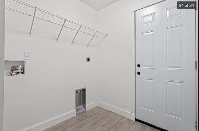clothes washing area with laundry area, baseboards, hookup for a washing machine, wood tiled floor, and hookup for an electric dryer