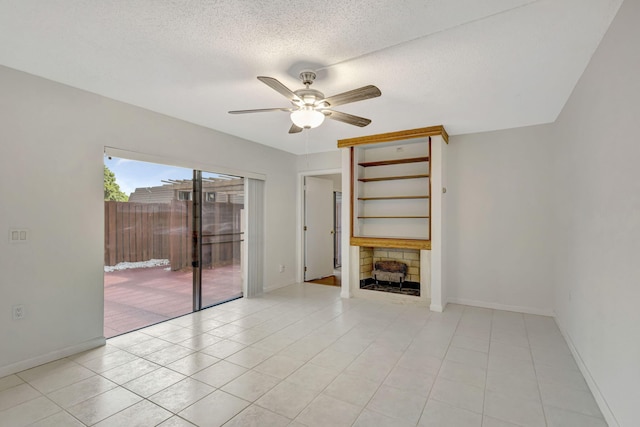 unfurnished living room with a textured ceiling, ceiling fan, light tile patterned flooring, and baseboards