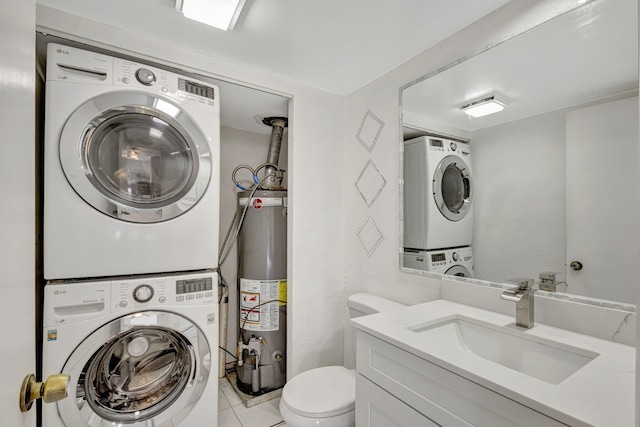 half bathroom with tile patterned flooring, vanity, gas water heater, toilet, and stacked washer and clothes dryer