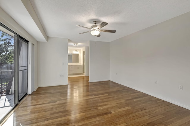 unfurnished room featuring baseboards, a textured ceiling, ceiling fan, and wood finished floors