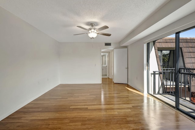 unfurnished room featuring a ceiling fan, a textured ceiling, visible vents, and wood finished floors