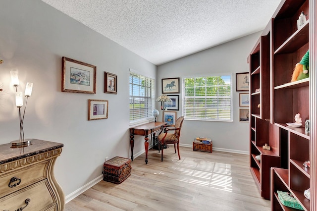 office with a textured ceiling, lofted ceiling, baseboards, and light wood finished floors