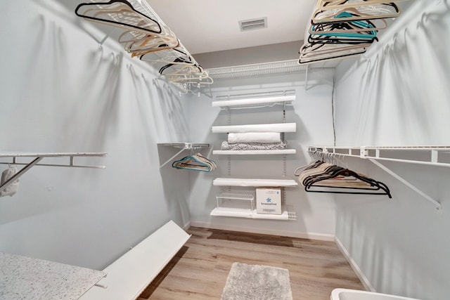 walk in closet with visible vents and wood finished floors