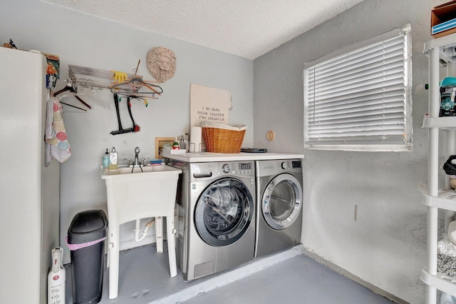 washroom with separate washer and dryer, laundry area, and a textured ceiling