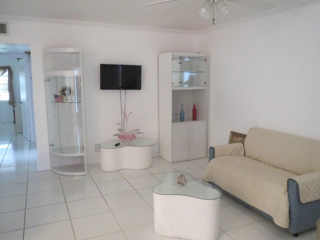 living area featuring ceiling fan, visible vents, ornamental molding, and tile patterned flooring