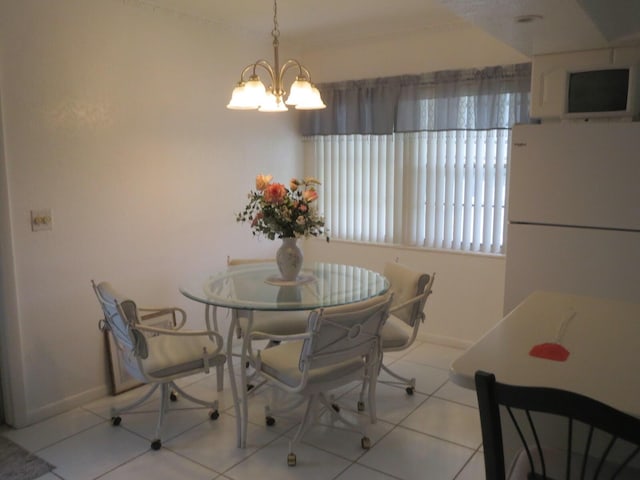 dining space featuring baseboards, a notable chandelier, and tile patterned flooring