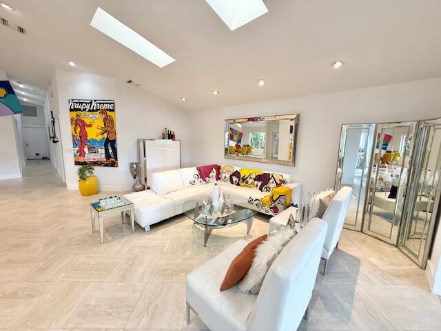 5534 Ainsley Ct, Boynton Beach, FL 33437 - living area with a skylight, lofted ceiling, recessed lighting, and baseboards