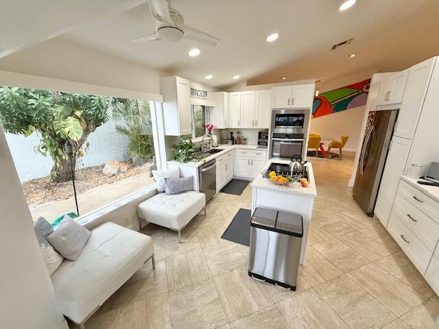 5534 Ainsley Ct, Boynton Beach, FL 33437 - kitchen featuring a center island, stainless steel appliances, light countertops, white cabinets, and a ceiling fan