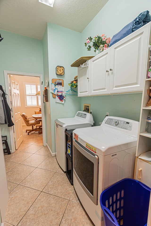 307 NW Clearview Ct, Port Saint Lucie, FL 34986 - laundry room featuring cabinet space, washing machine and dryer, light tile patterned floors, a textured ceiling, and baseboards