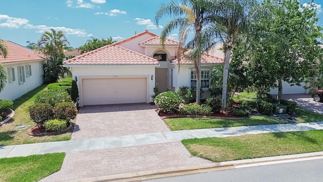 307 NW Clearview Ct, Port Saint Lucie, FL 34986 - mediterranean / spanish-style home with an attached garage, decorative driveway, a tile roof, and stucco siding