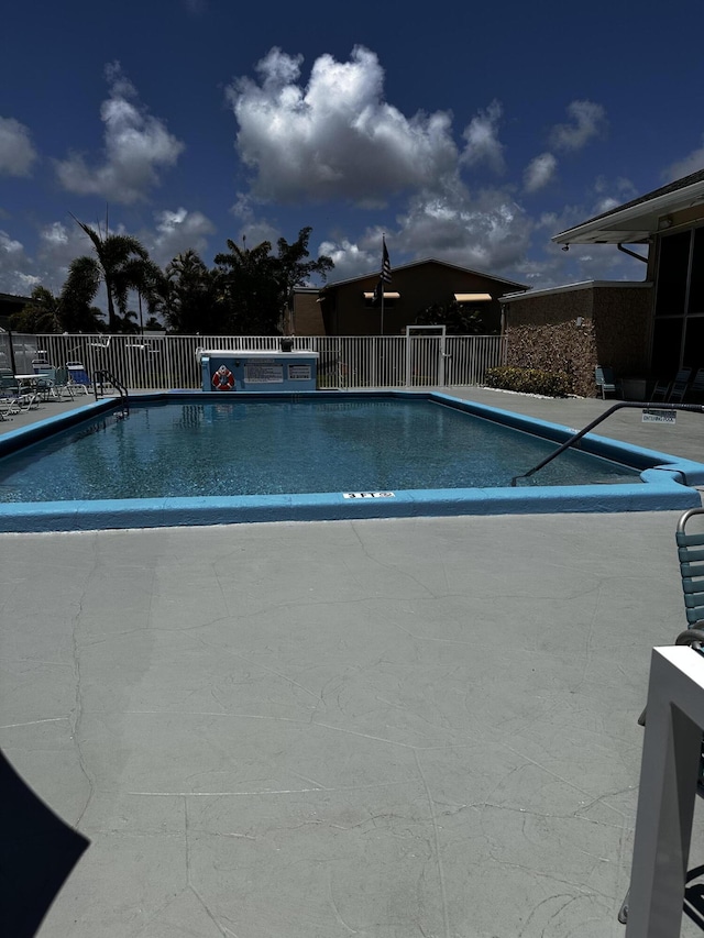community pool featuring fence and a patio area