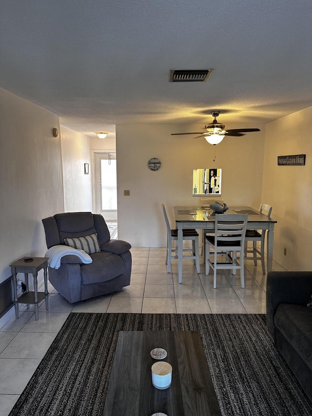 living area with light tile patterned floors and ceiling fan