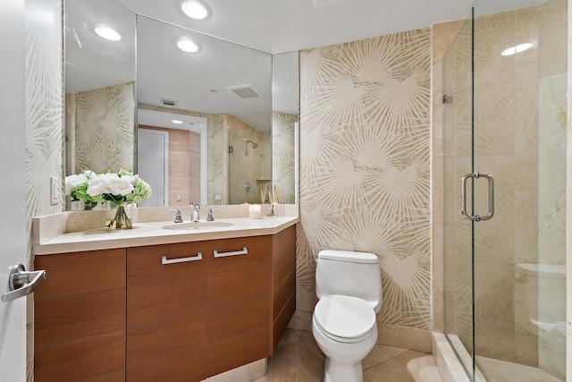 bathroom featuring a stall shower, vanity, toilet, and visible vents