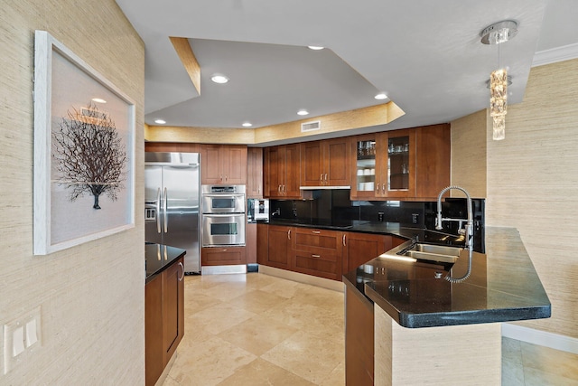 kitchen with a peninsula, glass insert cabinets, a sink, stainless steel appliances, and visible vents