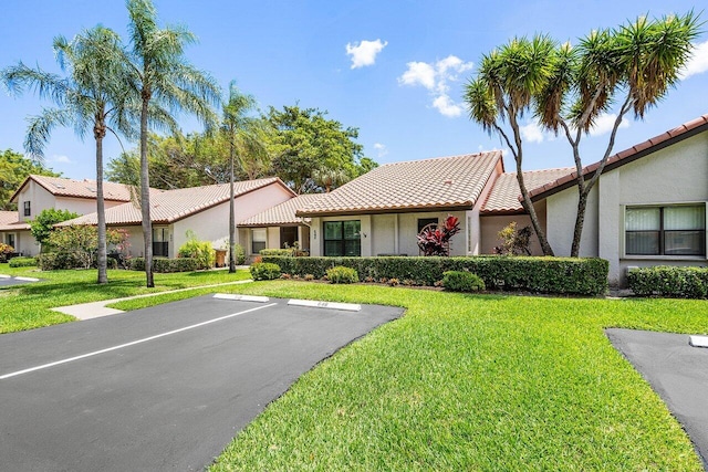648 Deer Creek Edgewater Dr, Deerfield Beach, FL 33442 - view of front of property featuring uncovered parking, stucco siding, a front yard, and a tile roof