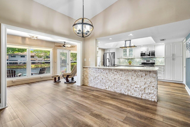 648 Deer Creek Edgewater Dr, Deerfield Beach, FL 33442 - kitchen featuring light countertops, white cabinets, ceiling fan with notable chandelier, a peninsula, and stainless steel appliances