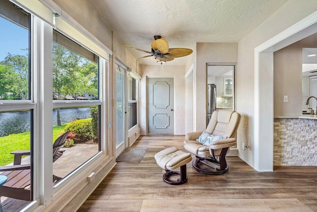 648 Deer Creek Edgewater Dr, Deerfield Beach, FL 33442 - sunroom with a textured ceiling, a water view, wood finished floors, and a wealth of natural light