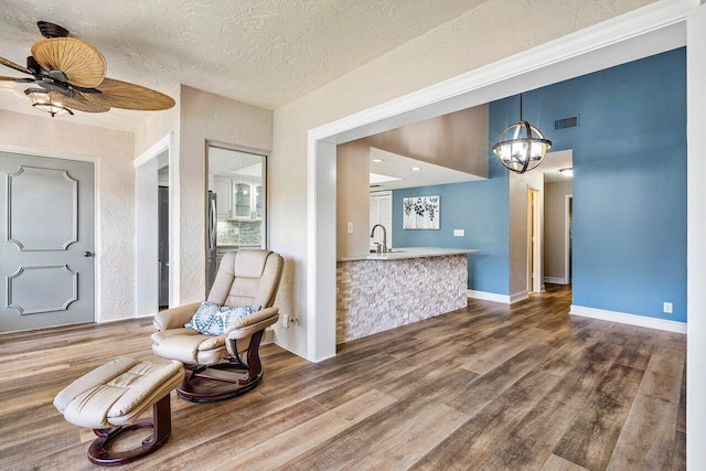 648 Deer Creek Edgewater Dr, Deerfield Beach, FL 33442 - sitting room with a textured ceiling, visible vents, baseboards, ceiling fan with notable chandelier, and dark wood-style floors