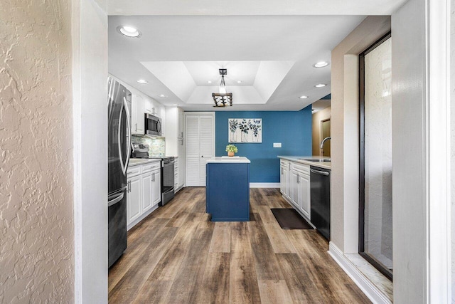 648 Deer Creek Edgewater Dr, Deerfield Beach, FL 33442 - kitchen featuring a kitchen island, a raised ceiling, a sink, a notable chandelier, and stainless steel appliances