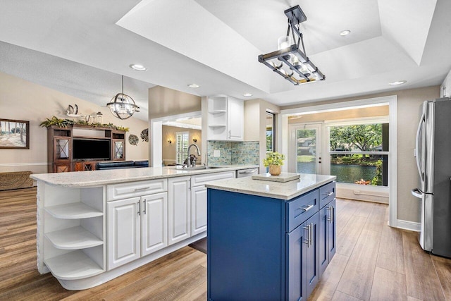 648 Deer Creek Edgewater Dr, Deerfield Beach, FL 33442 - kitchen with an inviting chandelier, open shelves, stainless steel appliances, a sink, and blue cabinetry