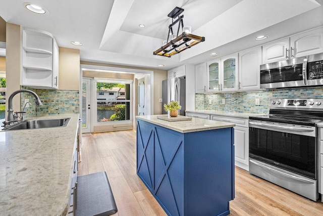 648 Deer Creek Edgewater Dr, Deerfield Beach, FL 33442 - kitchen with a sink, a center island, stainless steel appliances, white cabinetry, and tasteful backsplash