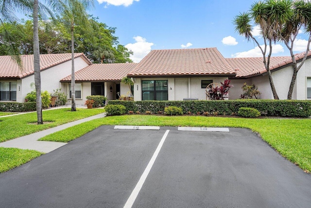 648 Deer Creek Edgewater Dr, Deerfield Beach, FL 33442 - view of front facade with a front lawn, uncovered parking, and stucco siding