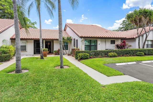 648 Deer Creek Edgewater Dr, Deerfield Beach, FL 33442 - view of front of home featuring a front lawn, uncovered parking, stucco siding, and a tiled roof