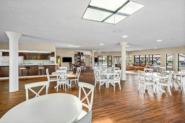 648 Deer Creek Edgewater Dr, Deerfield Beach, FL 33442 - dining room featuring decorative columns, a textured ceiling, a skylight, wood finished floors, and recessed lighting