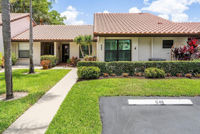 648 Deer Creek Edgewater Dr, Deerfield Beach, FL 33442 - mediterranean / spanish-style home featuring a tiled roof, stucco siding, uncovered parking, and a front lawn