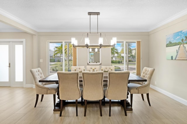 dining room featuring a chandelier, plenty of natural light, light wood-type flooring, crown molding, and baseboards