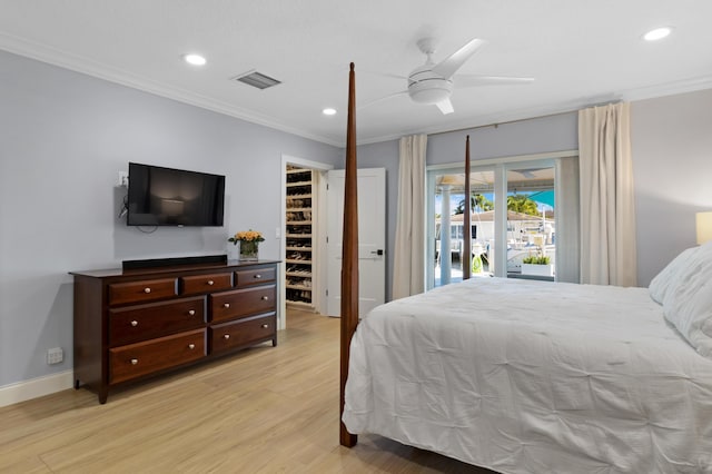 bedroom featuring ornamental molding, light wood-style floors, recessed lighting, a spacious closet, and access to outside