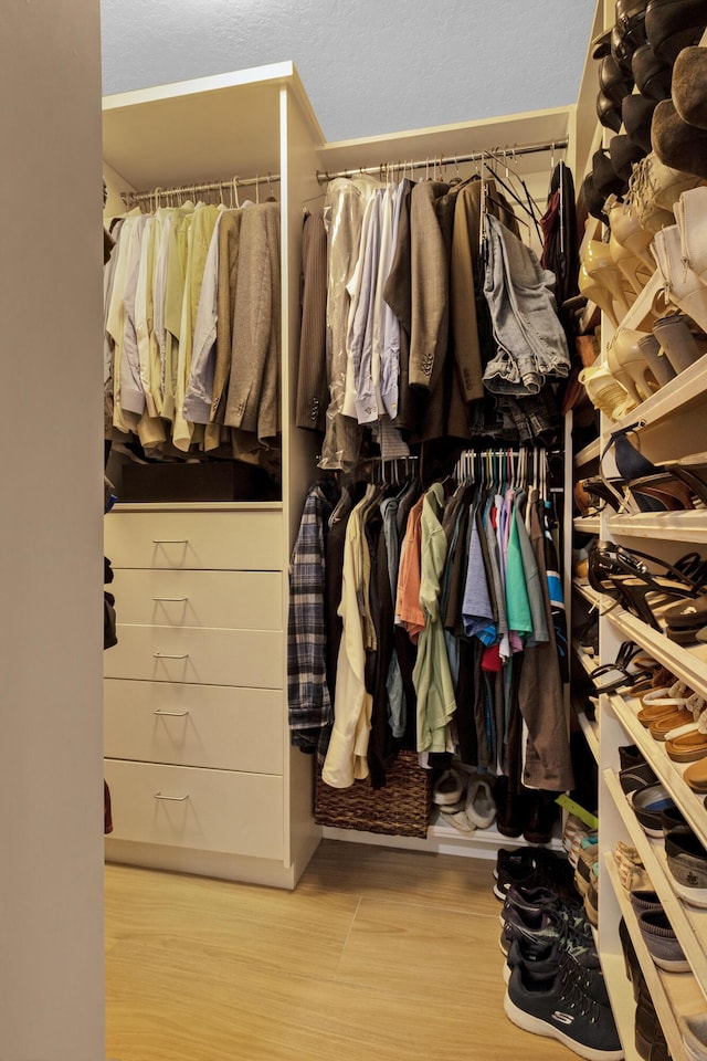 walk in closet with wood finished floors
