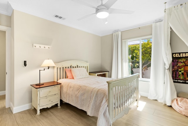 bedroom featuring light wood-type flooring, crown molding, baseboards, and a ceiling fan