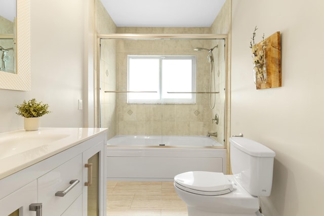 bathroom with toilet, vanity, and bath / shower combo with glass door