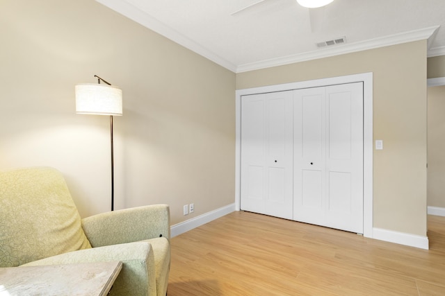 sitting room featuring crown molding, light wood-style floors, baseboards, and ceiling fan