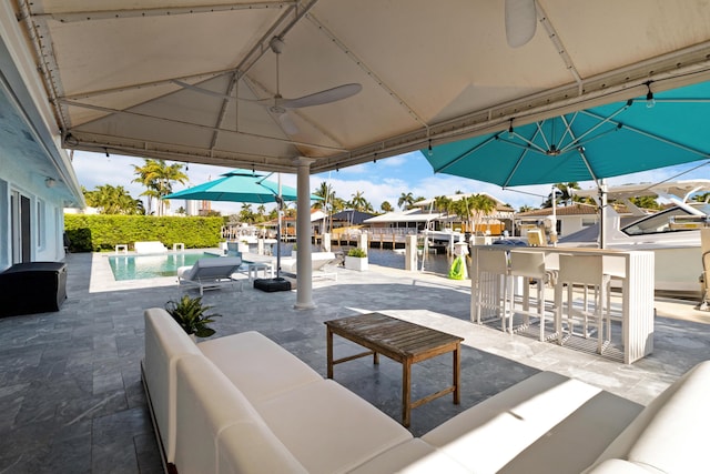 view of patio / terrace featuring an outdoor pool, a water view, an outdoor hangout area, and a residential view