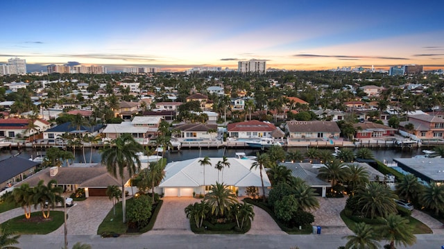 aerial view at dusk of a water view, a city view, and a residential view