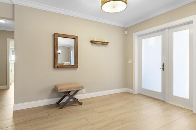 doorway with ornamental molding, light wood-style floors, and baseboards