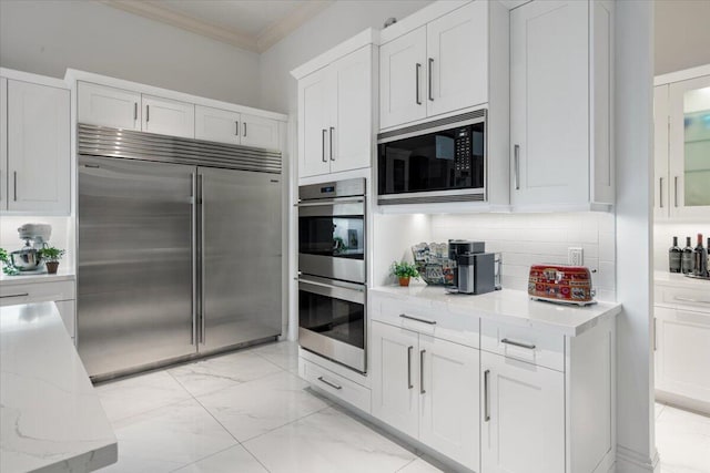 6940 NW 25th Way, Boca Raton, FL 33496 - kitchen featuring built in appliances, ornamental molding, light marble finish floors, decorative backsplash, and white cabinets